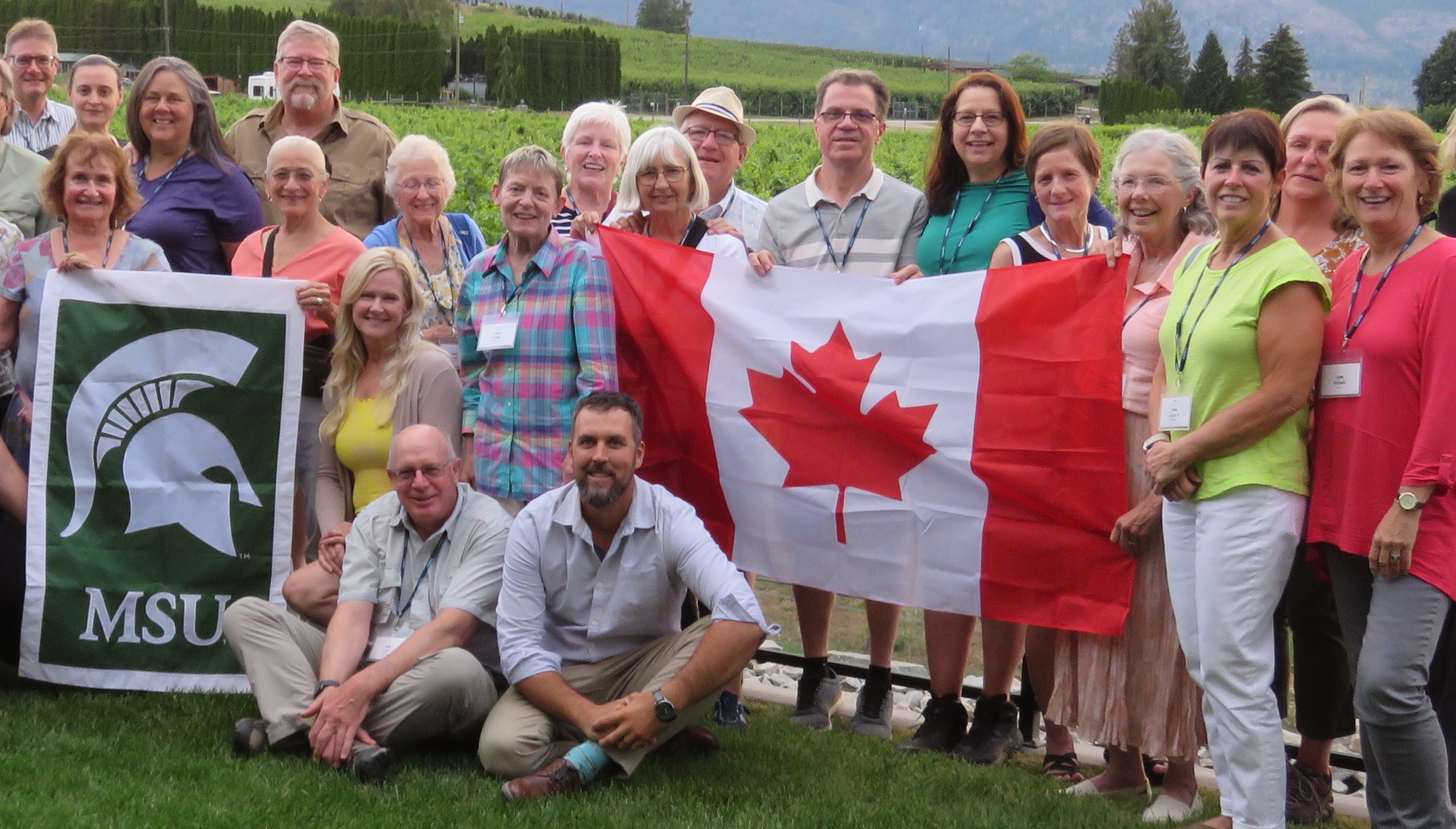 Catherine Stedman and fellow MSU Extension Master Gardeners and companions pose with MSU and Canadian flags during an educational trip to Western Canada.